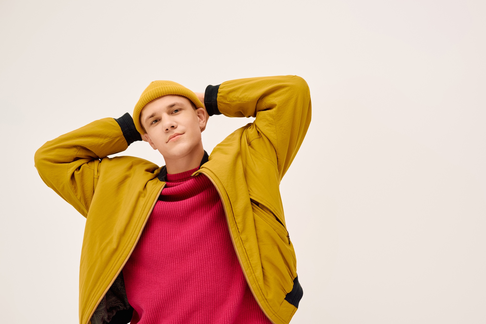 Trendy young man showcasing fashionable attire in modern studio setting