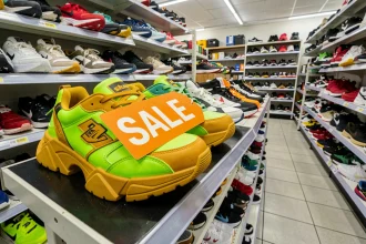 Chaussures moches en promotion sur un rayon de magasin discount avec étiquette de soldes orange